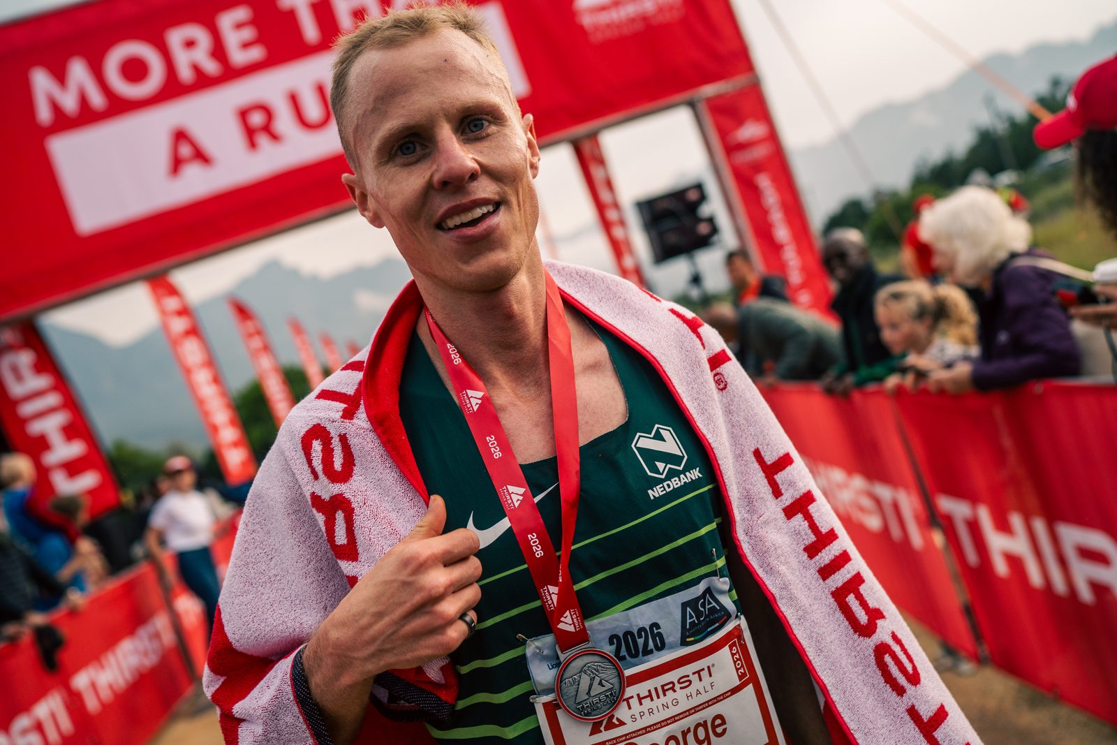 A runner with his medal at the THIRSTI finish line